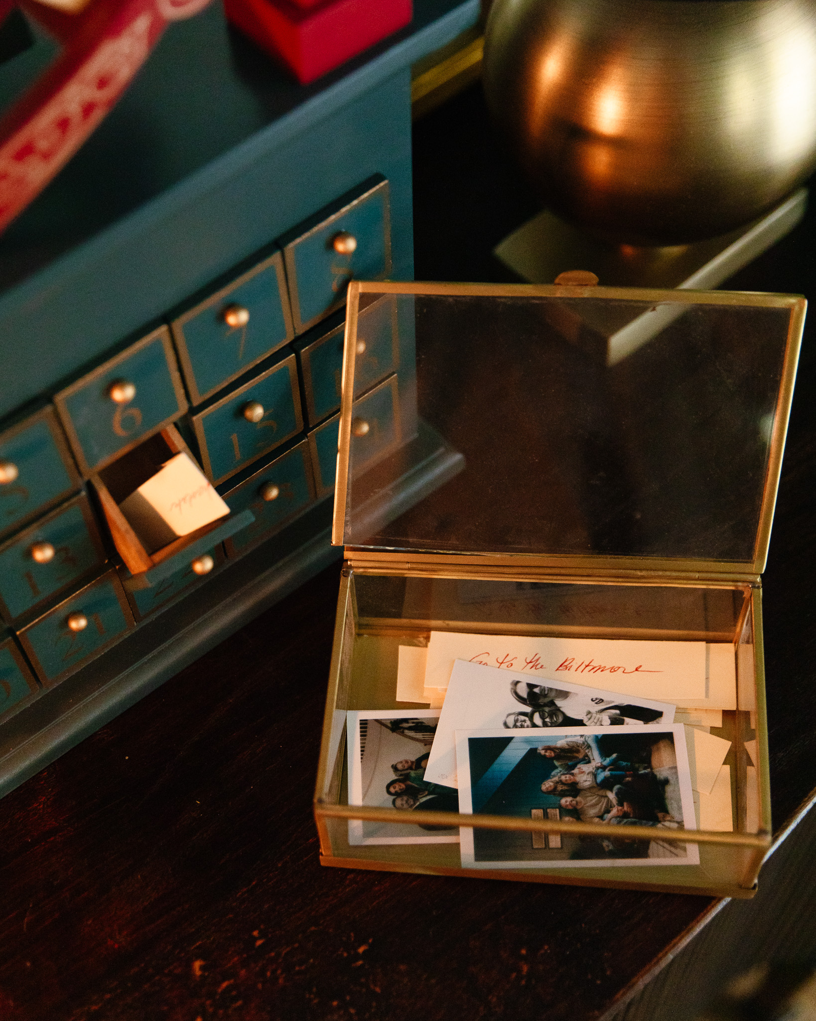 A little glass box with a note that says "Go to the BIltmore" next to the green wooden advent calendar