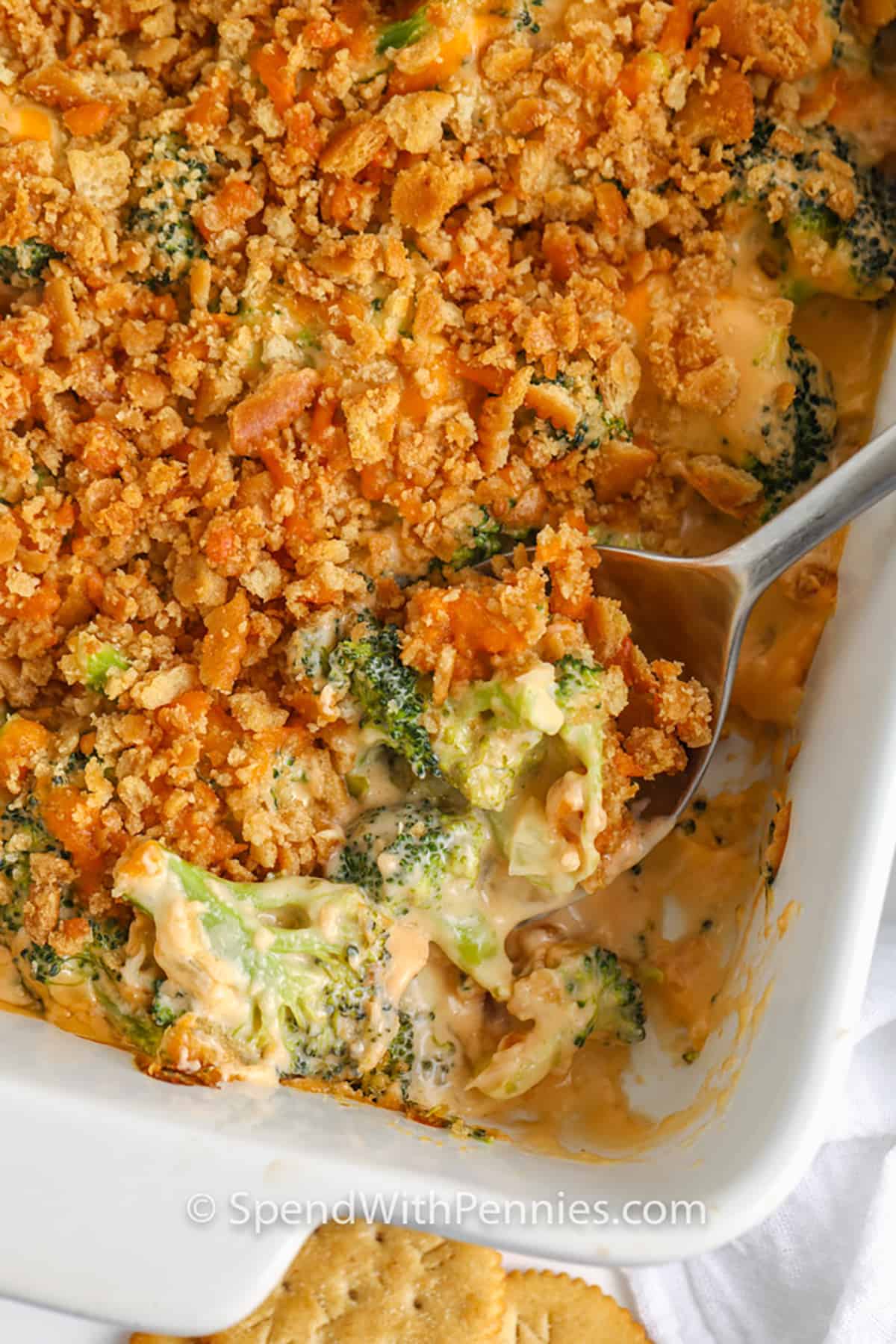 cooked Cheesy Broccoli Casserole in the dish with a spoon