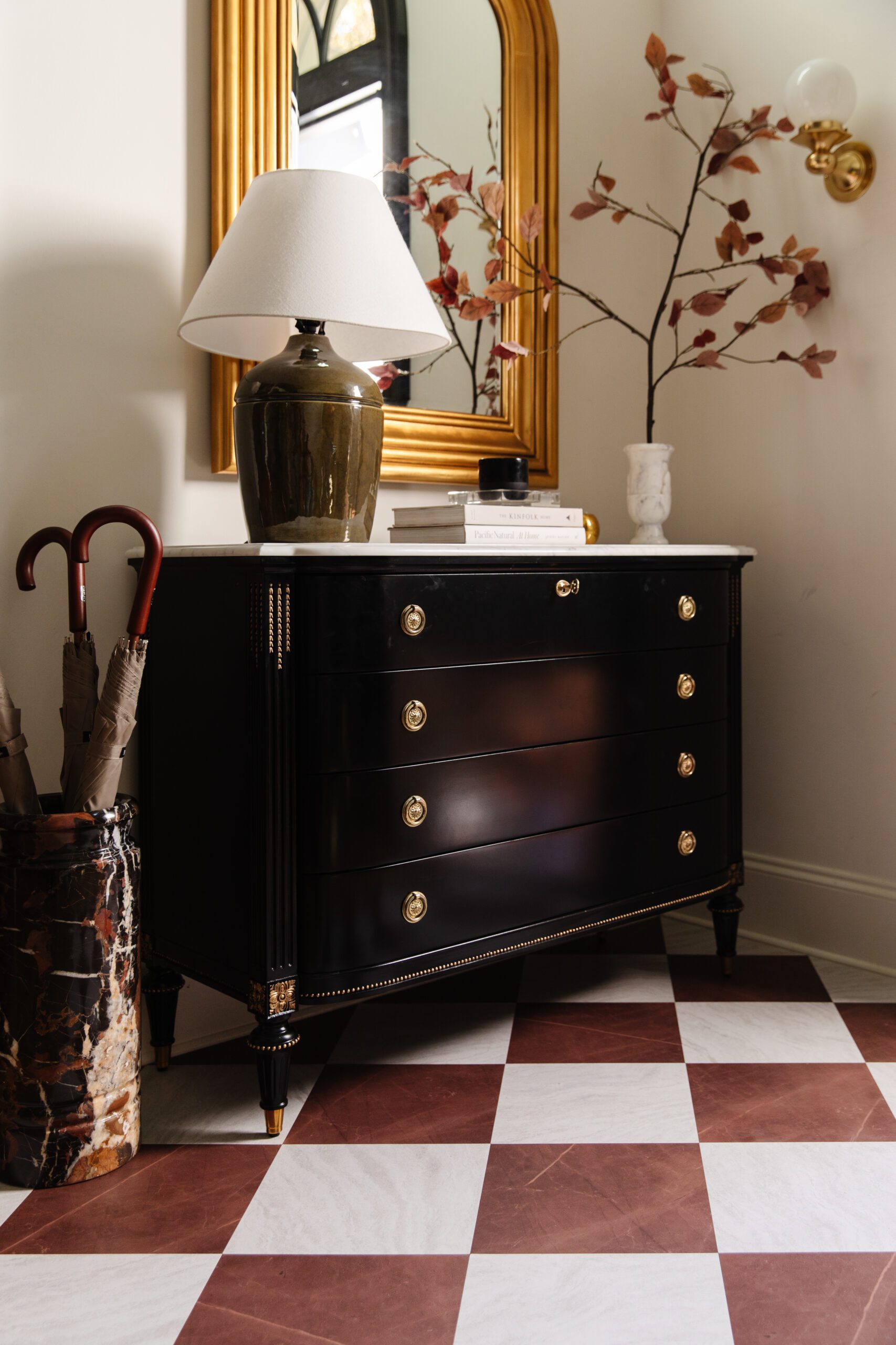 A front entry dresser featuring FloorPops peel-and-stick floor tiles in red & white marble checkerboard