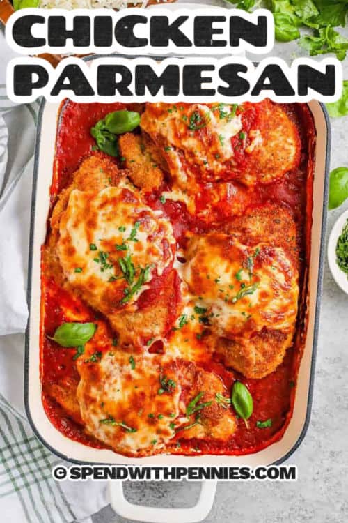 Try this easy chicken parmesan recipe for your next tasty dinner. With crispy breaded chicken breasts, marinara sauce, and melted cheese, it’s sure to be a family favorite. Preheat your oven, coat and brown the chicken, then bake with marinara and cheese until bubbly. Serve over pasta, garnished with fresh basil and parsley. It’s perfect for a weeknight meal or a special occasion. #spendwithpennies casserole dish of Chicken Parmesan with a title