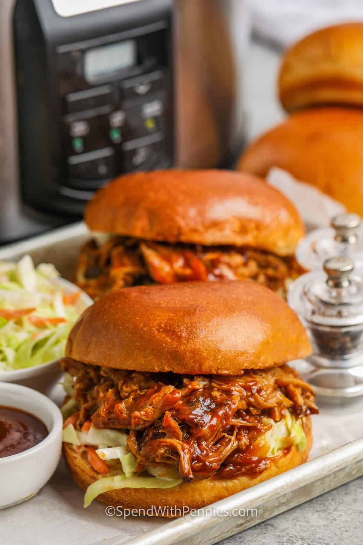 Slow Cooker Pulled Pork Sandwiches with slow cooker in the back