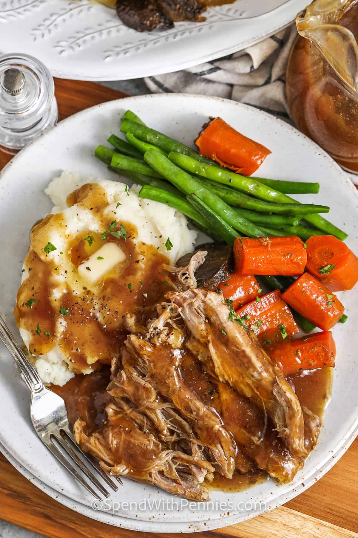 Crock Pot Pork Roast on a plate with carrots and beans