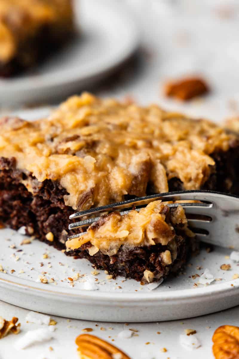 up close view of a slice of german chocolate sheet cake with fork taking bite out