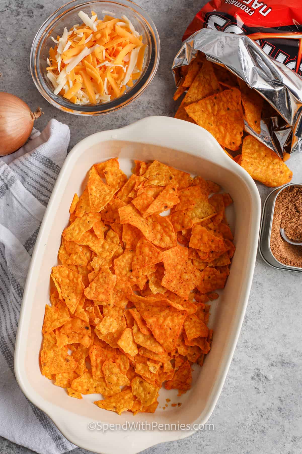 adding chips to dish to make Layered Dorito Casserole