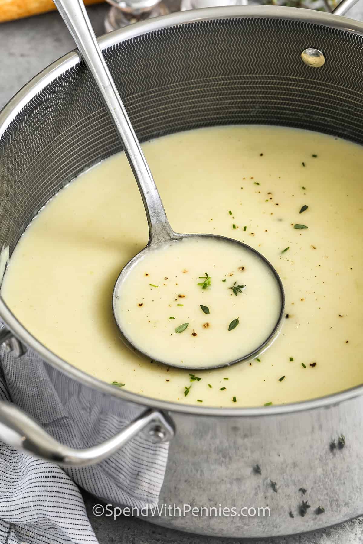 taking a spoonfull of Potato Leek Soup out of the pot