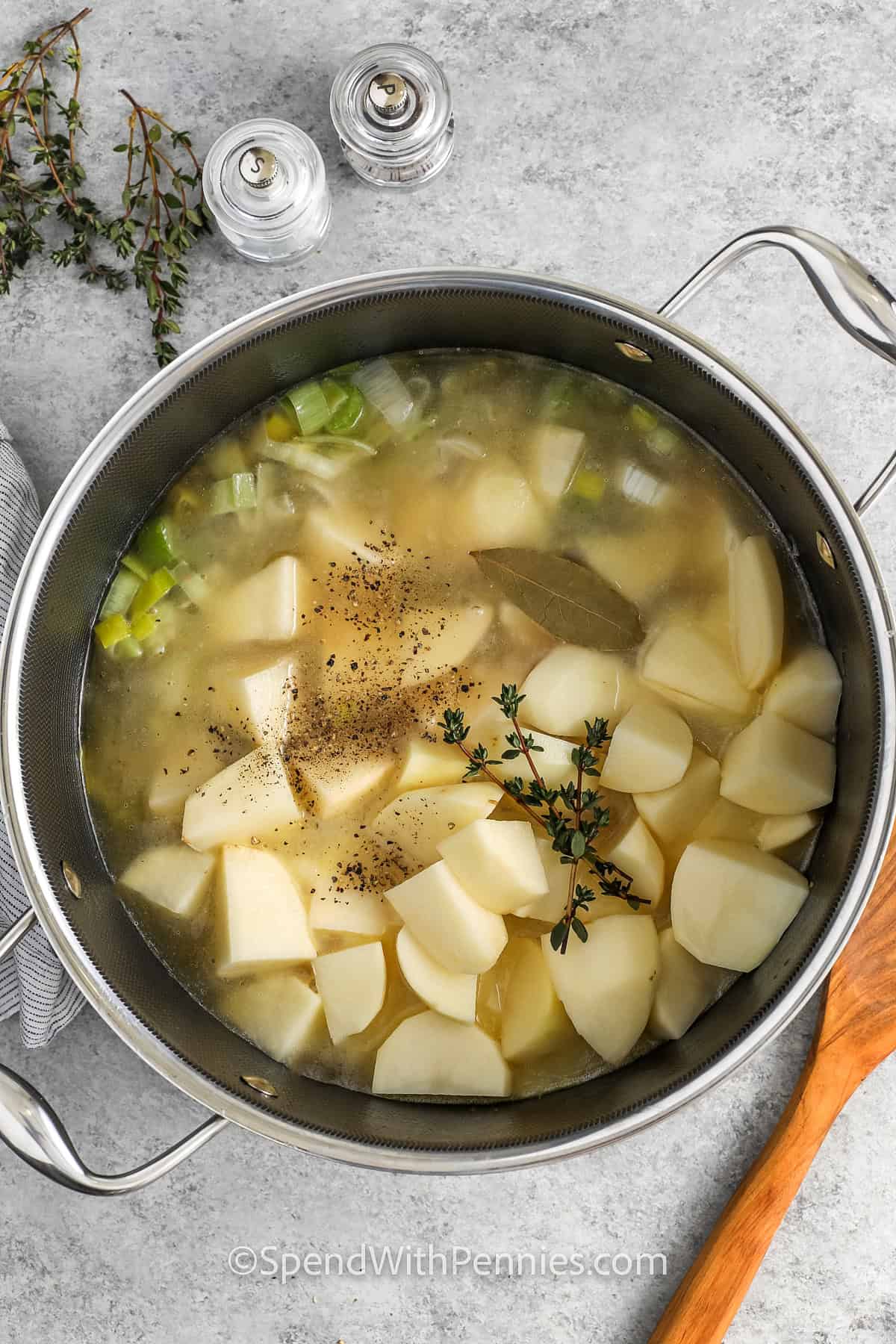 adding ingredients to pot to make Potato Leek Soup