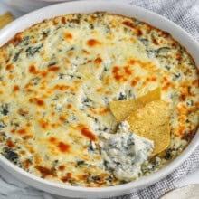 The Best Spinach Artichoke Dip in a dish with chips