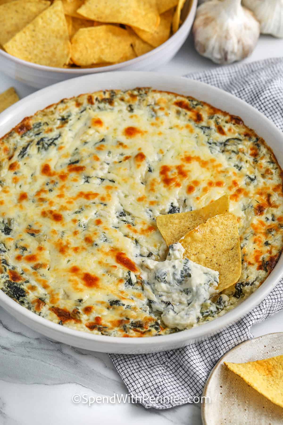 The Best Spinach Artichoke Dip in a dish with chips