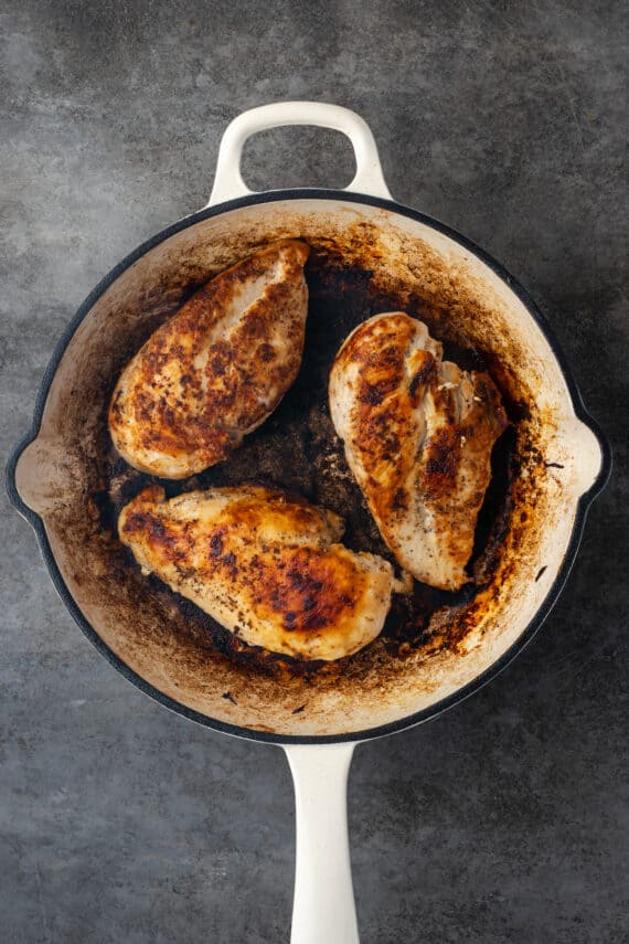 Seared chicken breasts in a skillet.