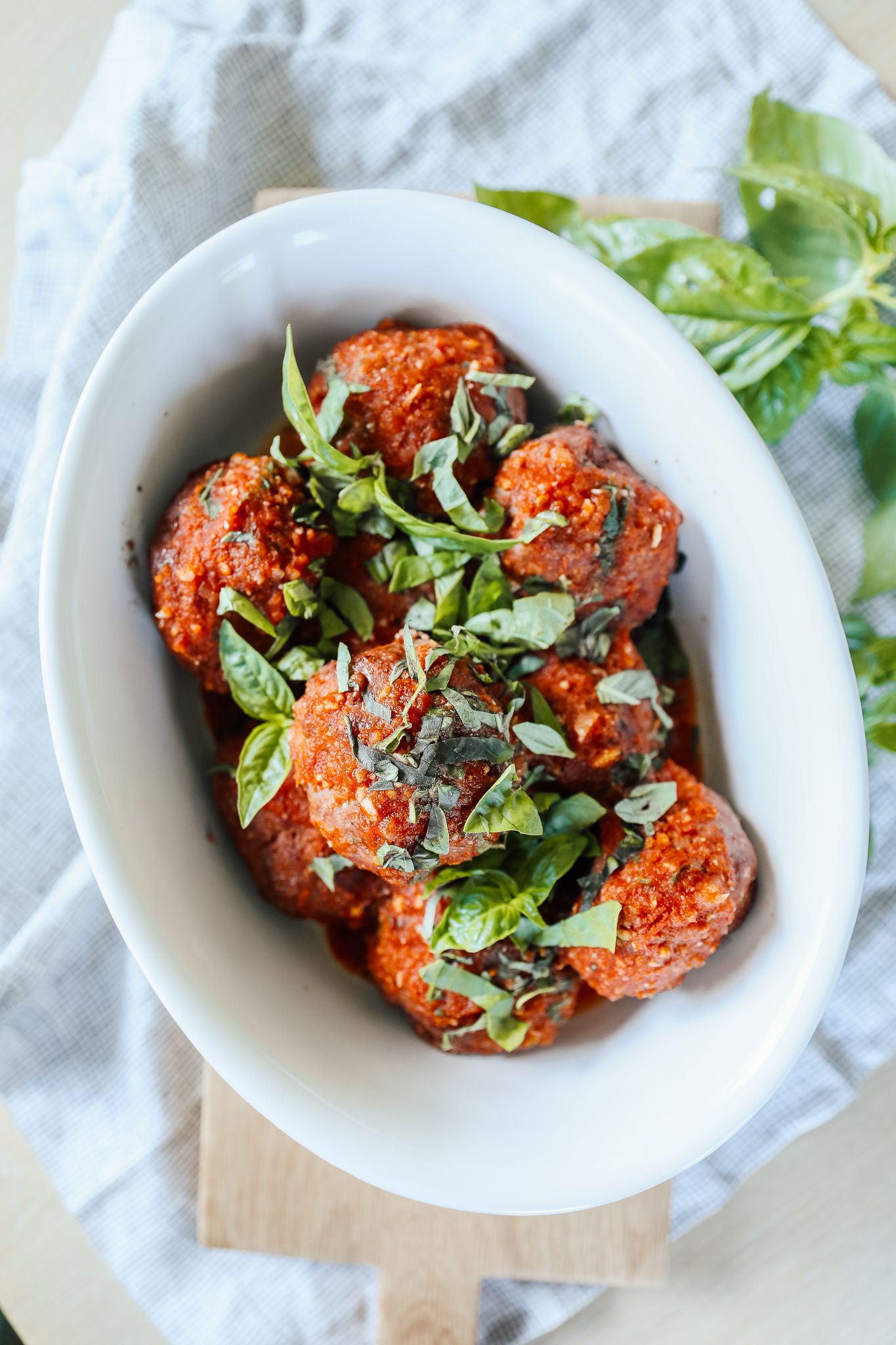 A bowl of smoky meatballs topped with basil slivers