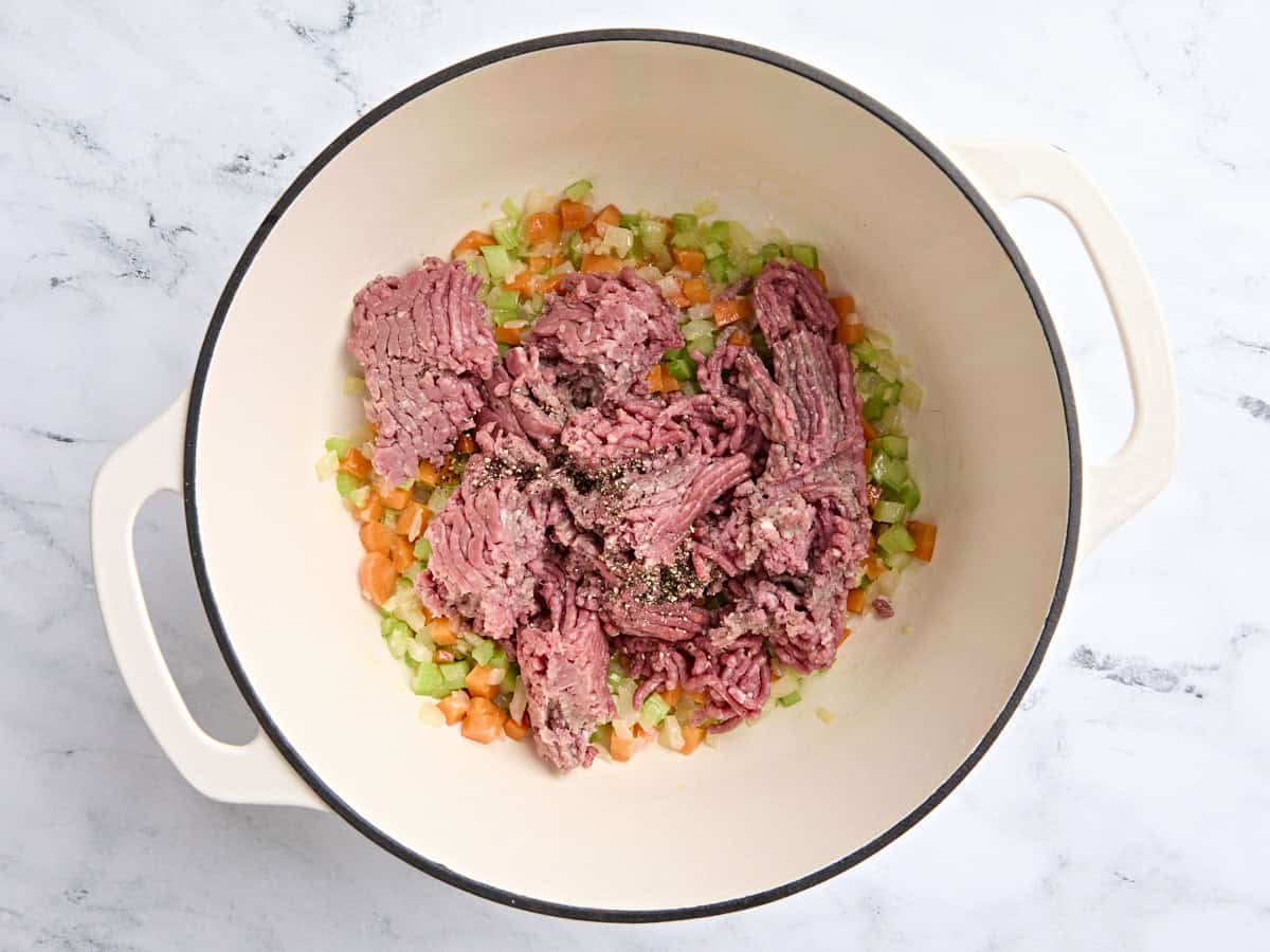 Ground beef added to a Dutch oven with the sauteed vegetables.