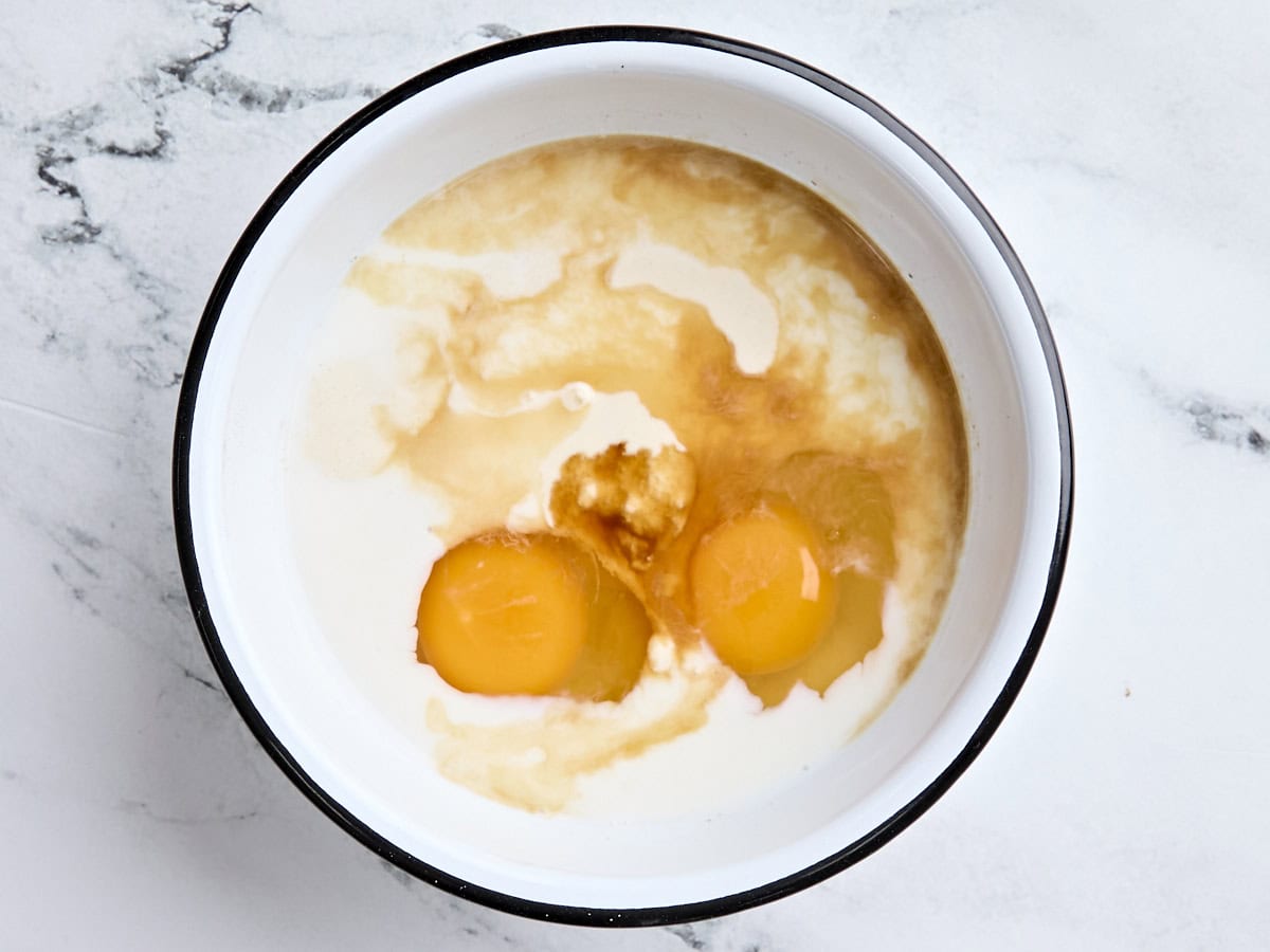 Sourdough discard, eggs, and milk in a mixing bowl.