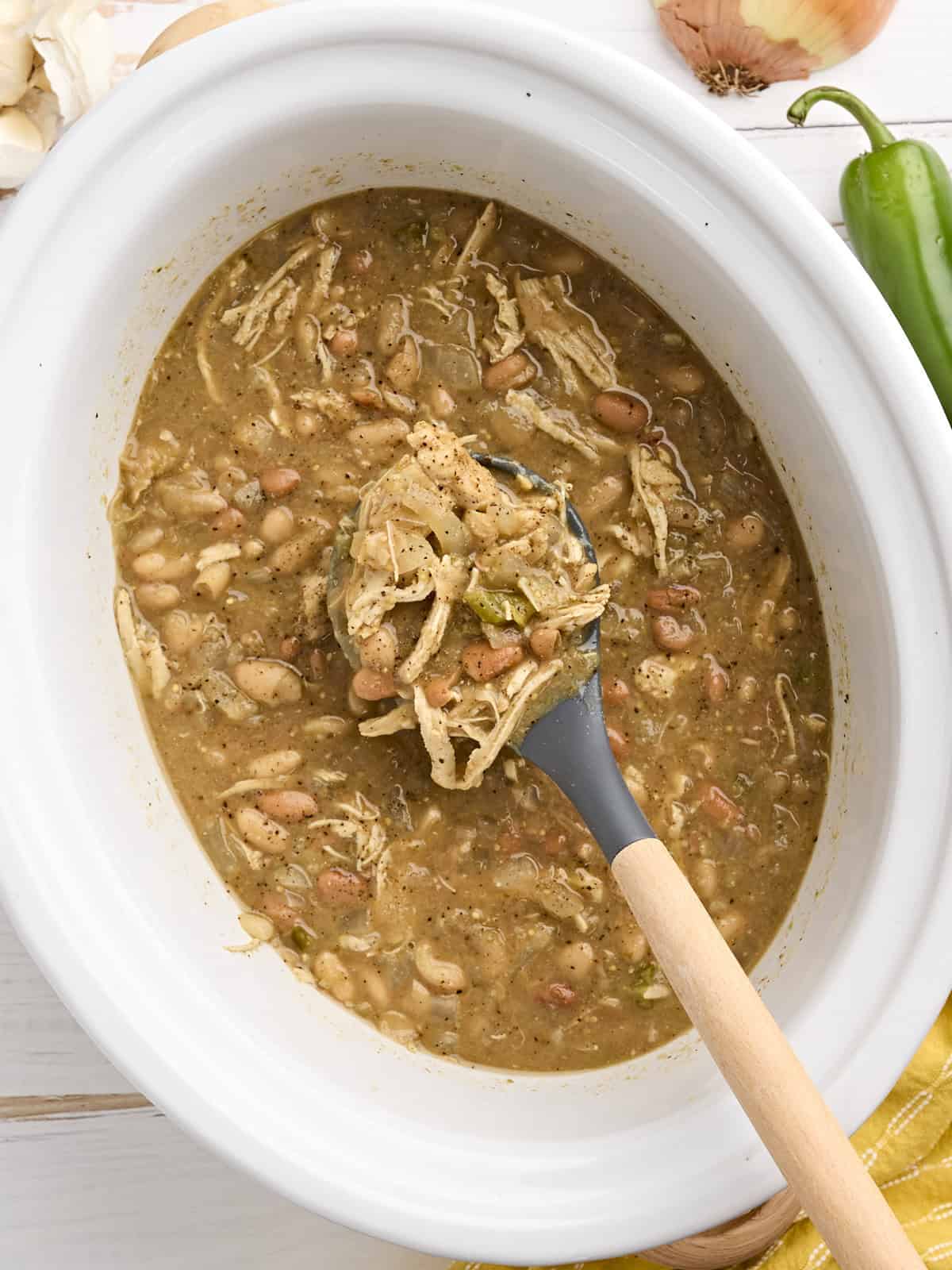 The slow cooker does all the work with this easy, flavorful, and healthy white chicken chili. This Overhead view of slow cooker white chicken chili in a crockpot.